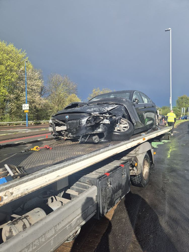 Accident-damaged saloon on the back of a recovery truck